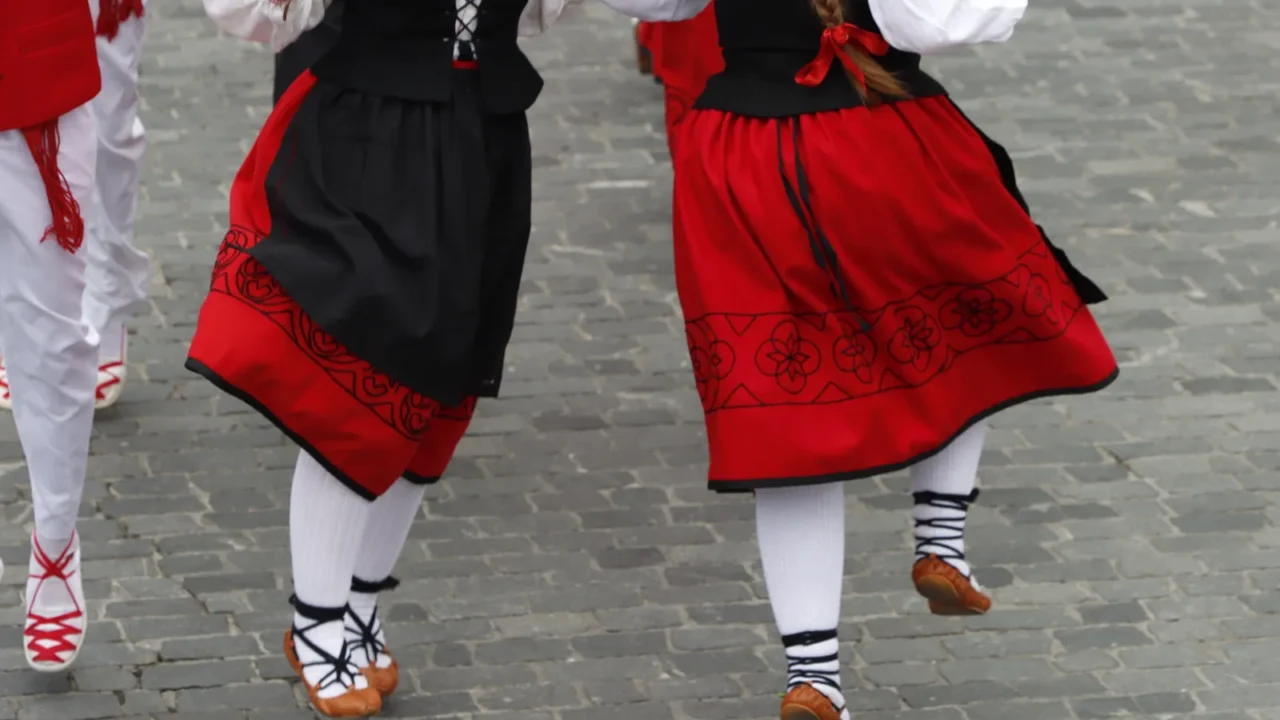 basque folk dancers performing in traditional costume on the streets
