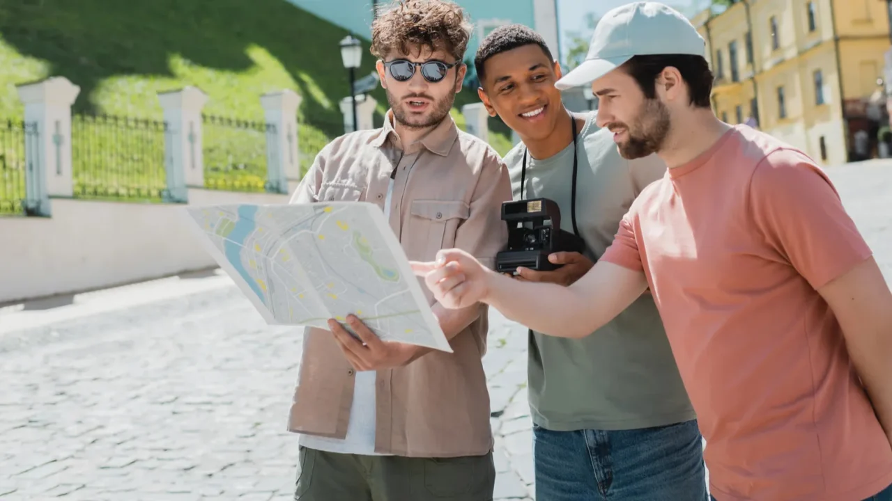 bearded tourist pointing at city map near tour guide and