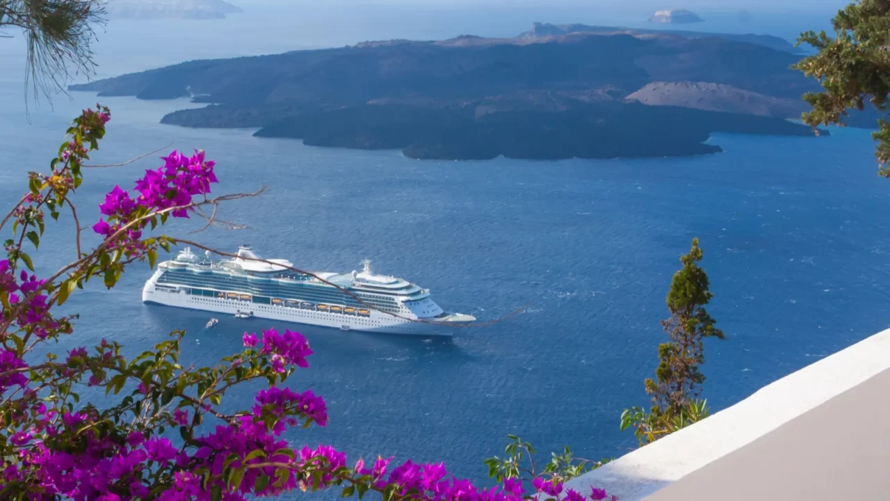 bougainvillea adorn walkway as passenger cruise ship anchors off the
