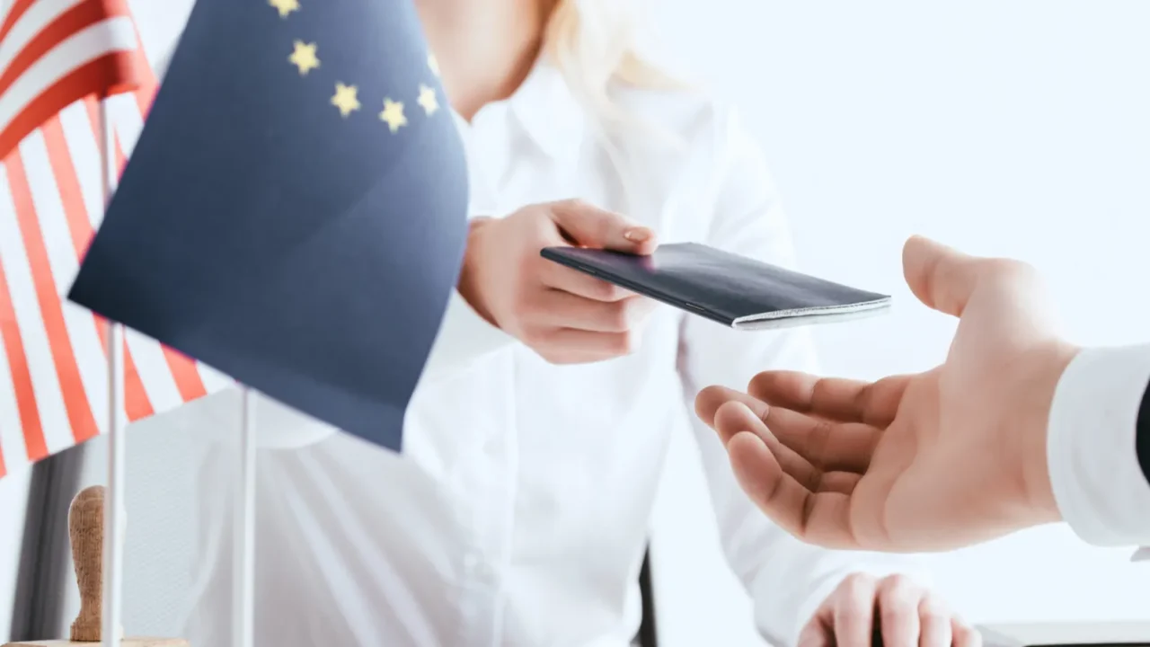 cropped view of woman giving passport to tourist near american