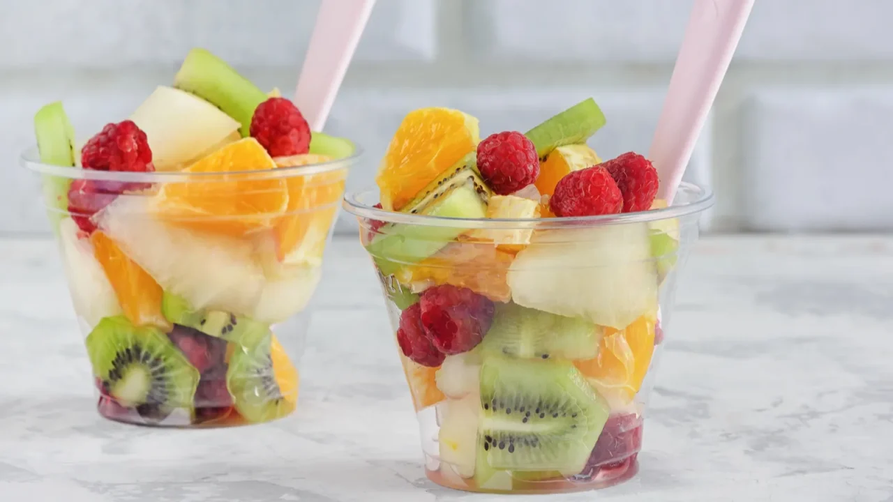 fresh assorted fruit salad in takeaway plastic cups