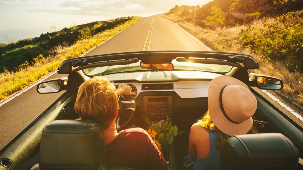 happy couple driving in convertible