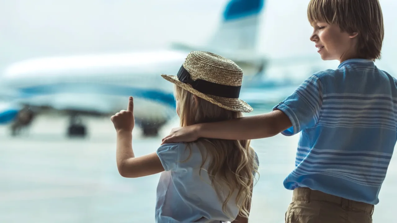 kids looking out window in airport