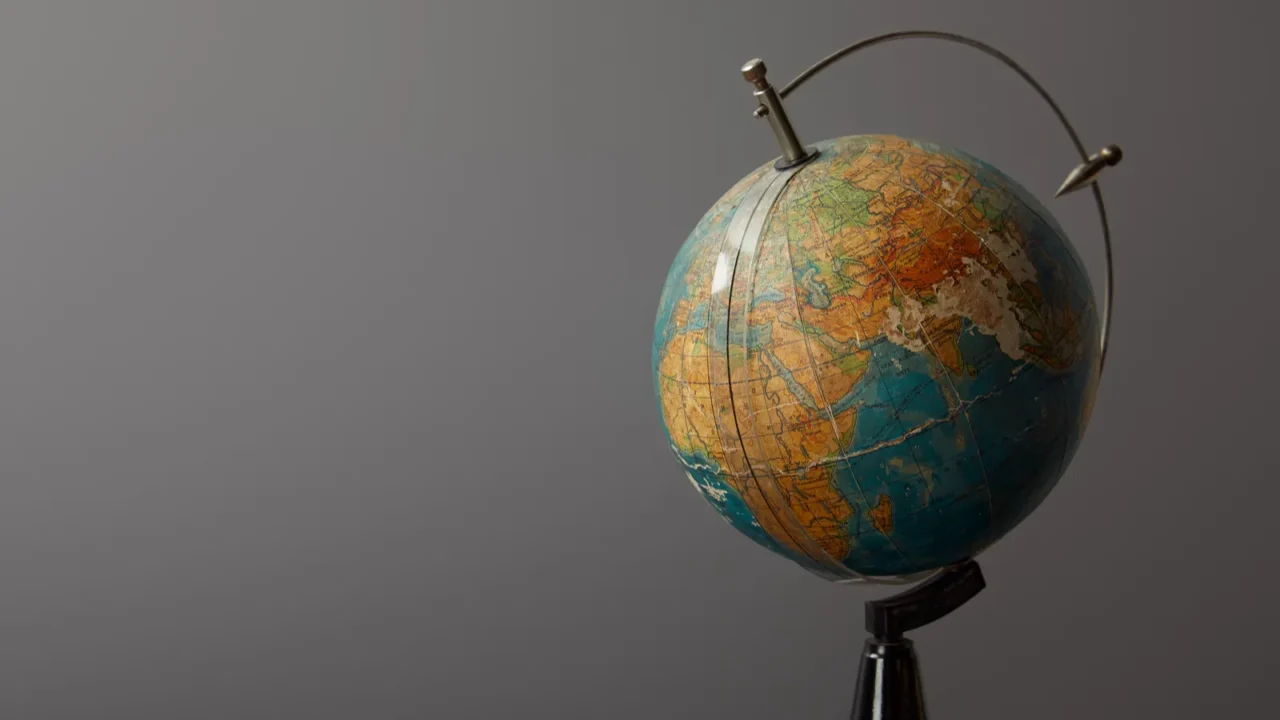 old globe on dark textured surface on grey