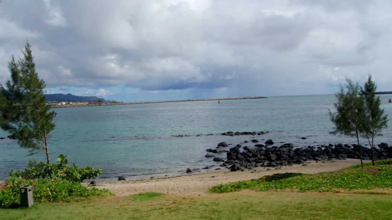 path to beach at kahului bay with trees and clouds