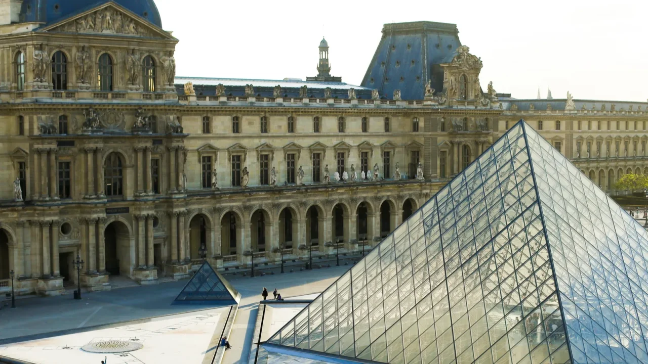 people walking in louvre near glass pyramid paris france