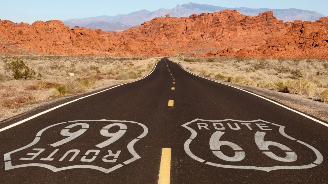 route 66 pavement sign with red rock mountains