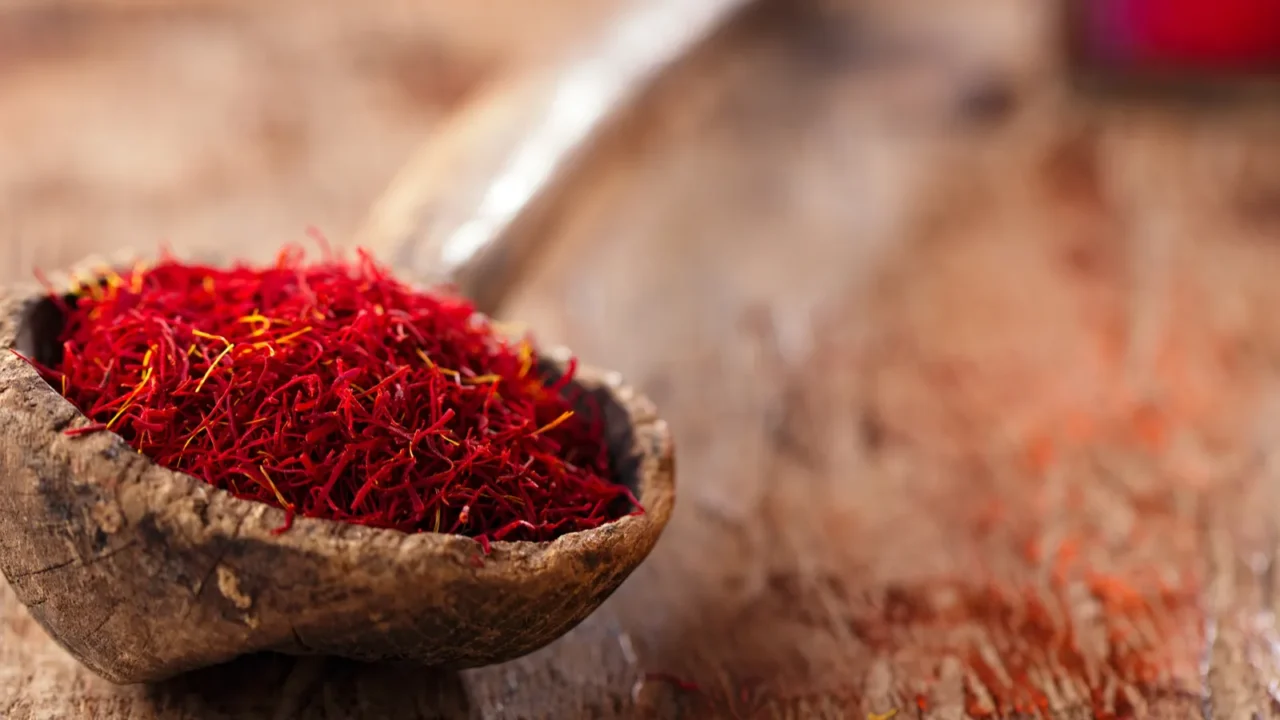 saffron spice in antique wooden spoon on old wood background