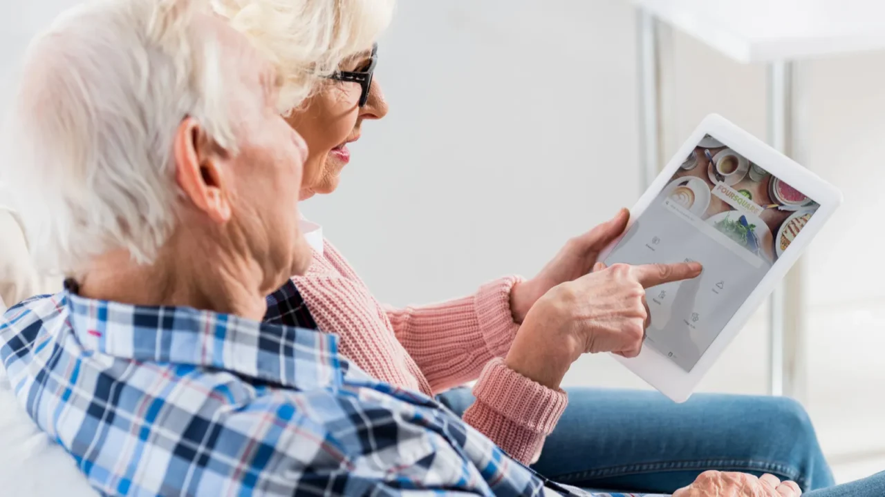 side view of senior couple using digital tablet with foursquare