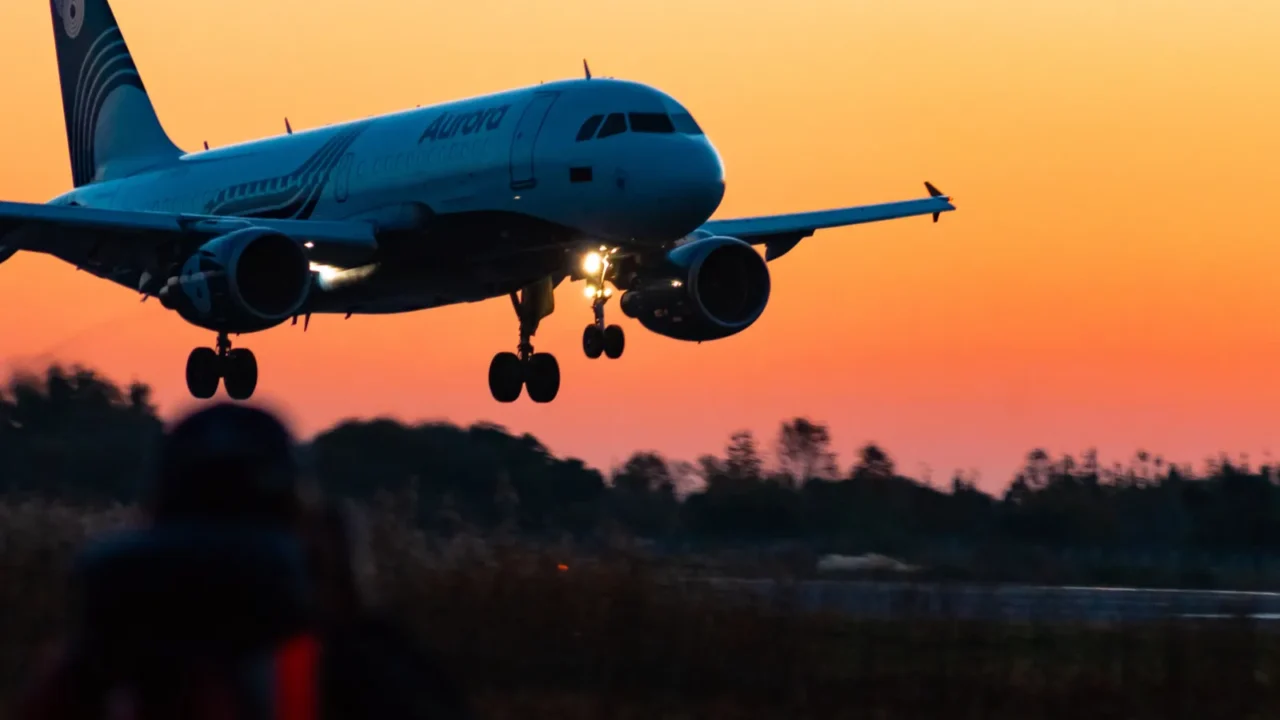 the plane lands on the runway at sunrise at high