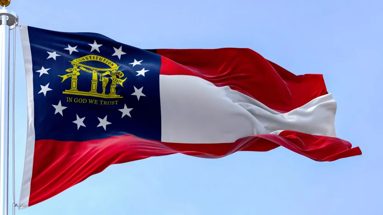 the state flag of georgia waving in the wind on