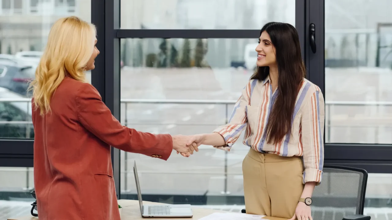 two hardworking women in an office sealing a deal through