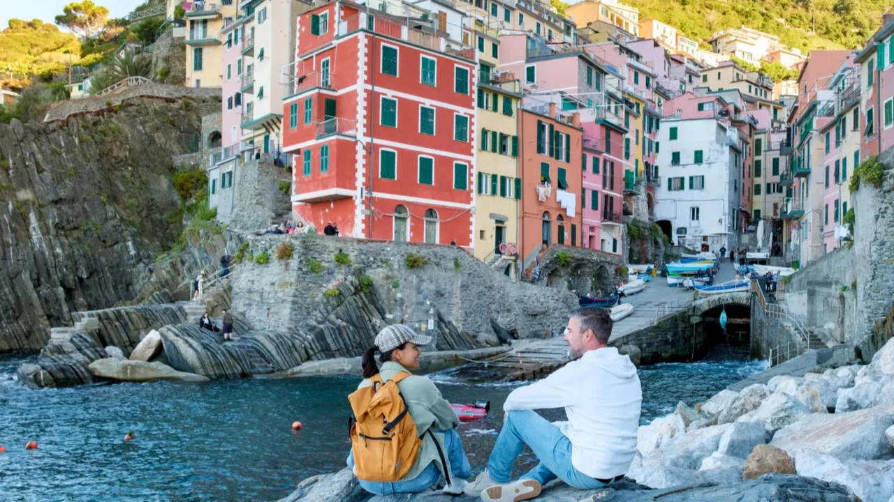 two travelers relax on the rocky shore surrounded by the