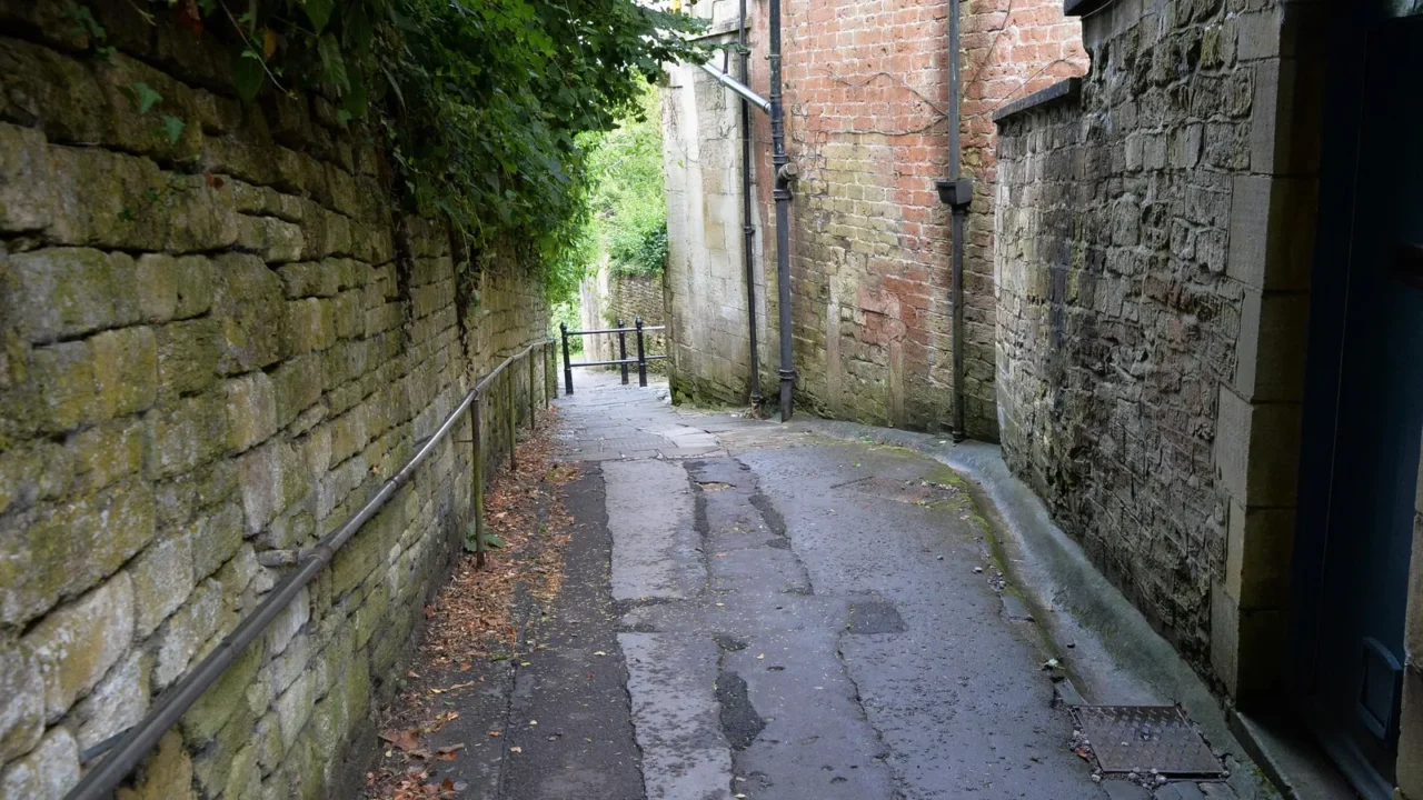 view of a dark alleyway leading up a hill