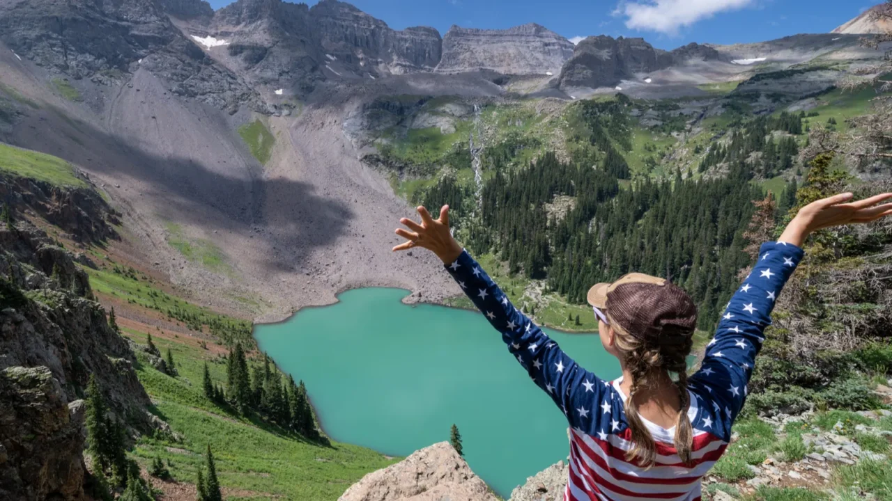 woman hiker wearing patriotic clothing enjoys the view at blue