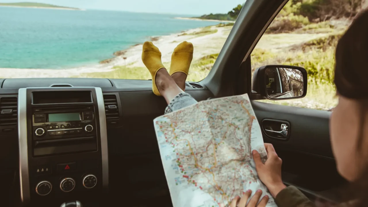 woman legs at car dashboard sea on background copy space