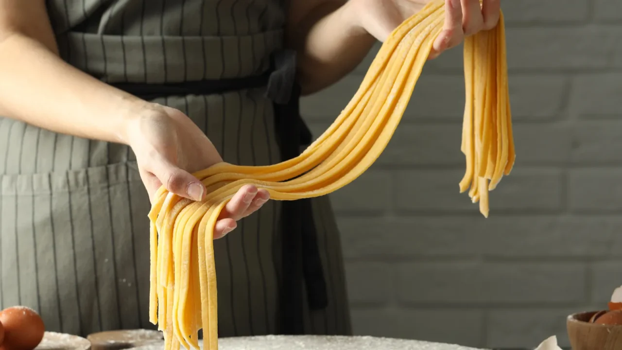 woman making homemade pasta at table closeup