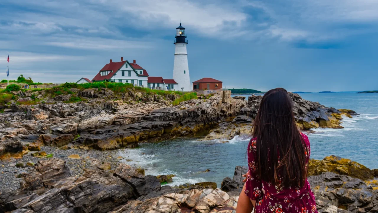 woman mesmerizing the view of portland head lighthouse in portland