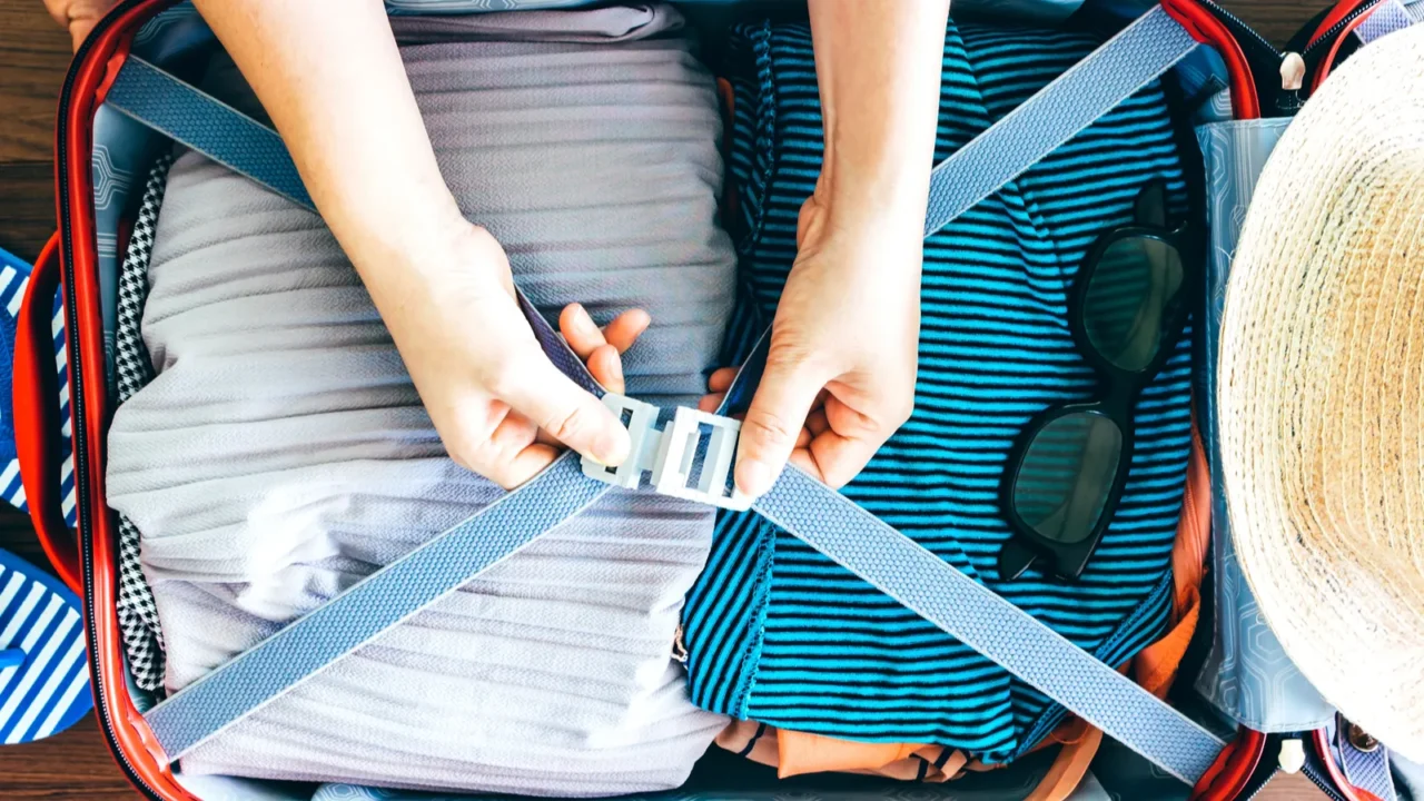 woman packing a luggage on wooden floor