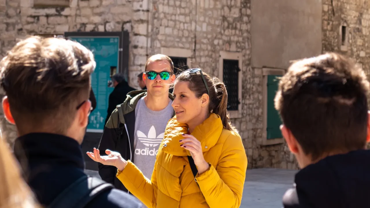 woman tourist guide talking to a group of travellers