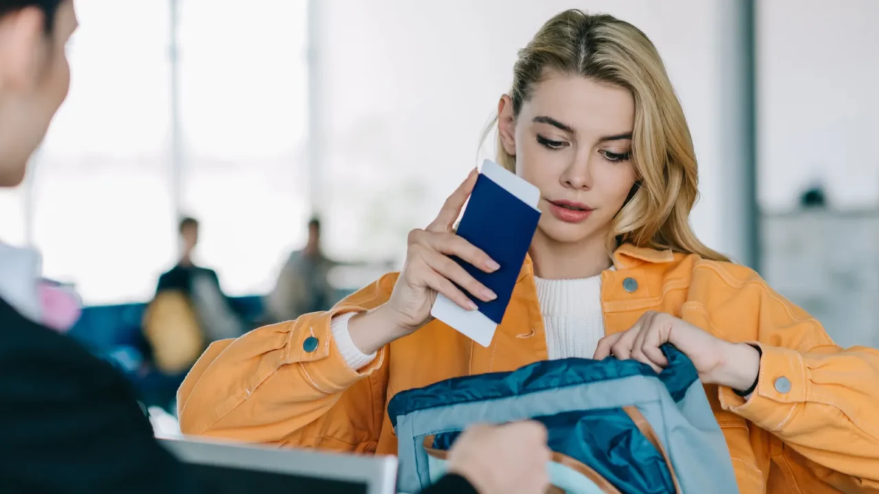 young woman putting passport with boarding pass into bag at
