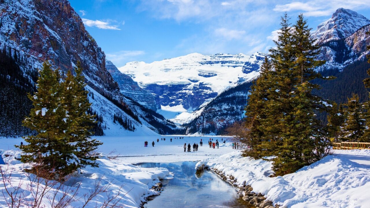 Frozen Lake Louise in the winter against the backdrop of the stunning Victoria Glacier. The iconic Lake Louise typically freezes from November to mid-April and draws visitors from all over the world.