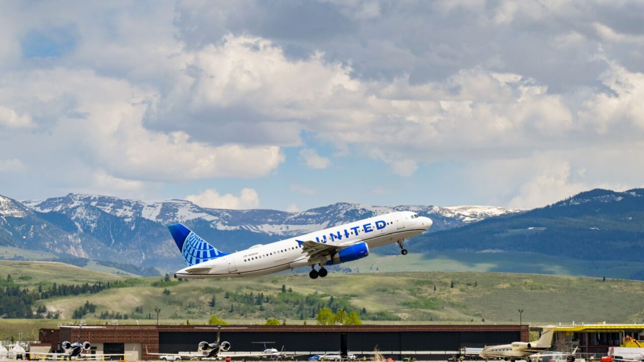 Jackson Hole, Utah, USA - Airbus A320-232 (registration N491UA) operated by United Airlines taking off from Jackson Hole airport with snow capped mountains in the background