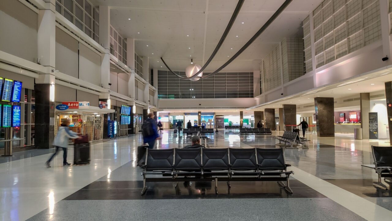 Baltimore, Maryland - February 22, 2019: Single man waits in a lobby, while everyone rushes around him.