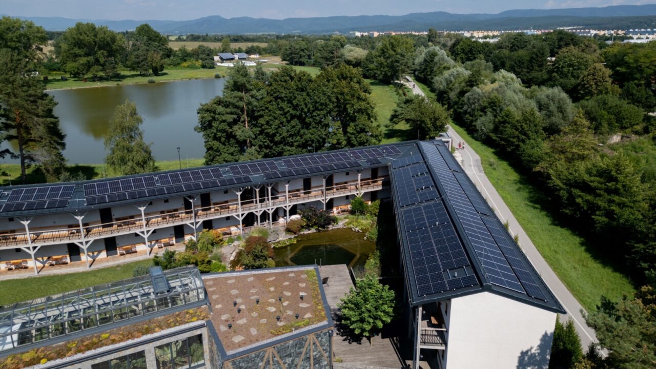 Aerial view of solar panels on a rooftop of hotel complex. Solar energy as renewable energy source in business.