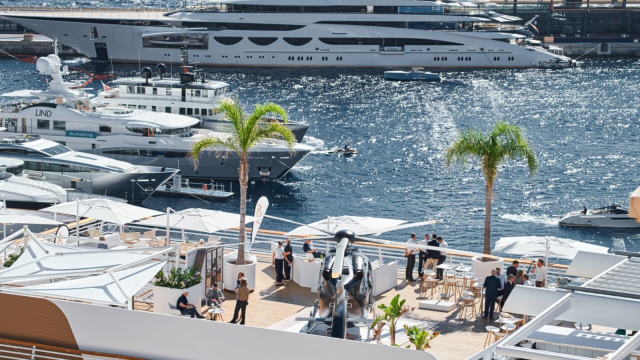 Monaco, Monte Carlo, 27 September 2022 - Rich clients visitors examine a helicopter standing on the deck of a yacht club, the largest fair yacht show, port Hercules, yacht brokers, sunny weather