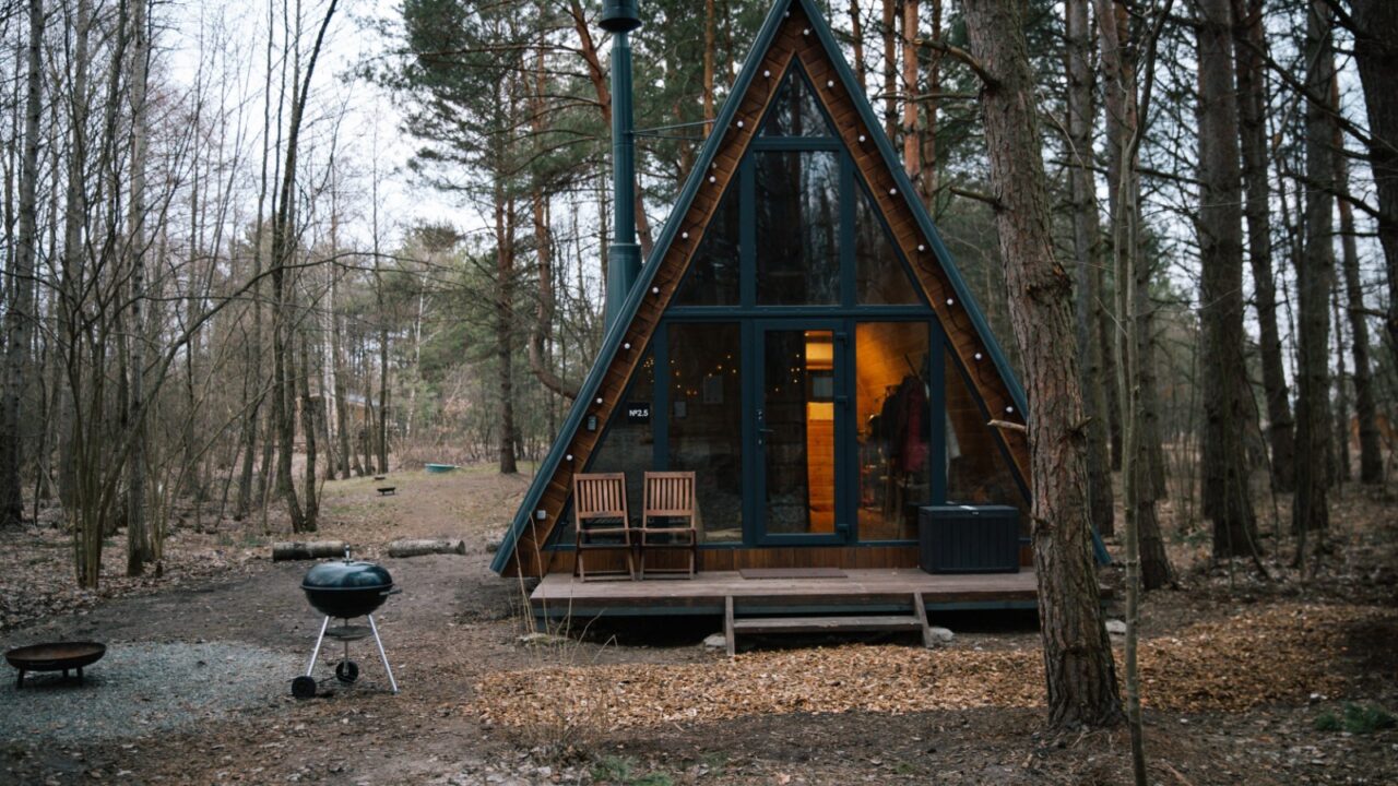A frame scandinavian modern tiny cabin with BBQ zone in the woods