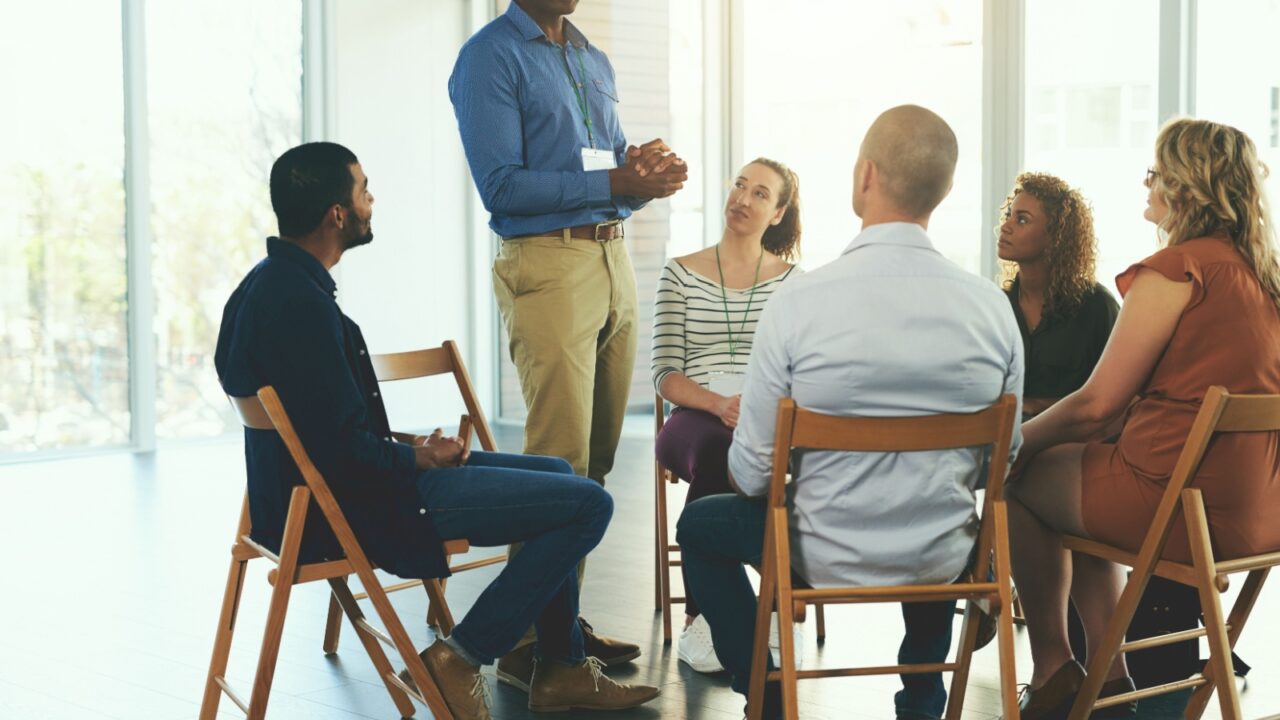 Meeting, people and collaboration speaking in office for teamwork, communication and diversity. Group, men and woman in boardroom discussion for company planning, brainstorming and working together