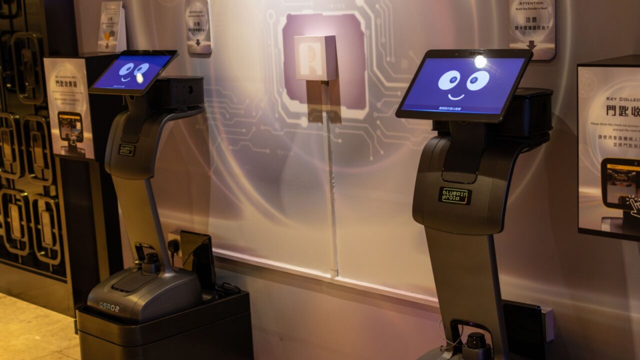 Hong Kong, China - March 21, 2024 : Two modern delivery robots with digital faces are standing in a hotel lobby, ready to assist guests