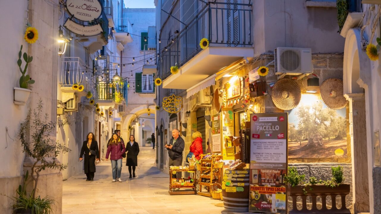 Monopoli, Italy, 20 of March 2025, narrow historic street with shops and cafes