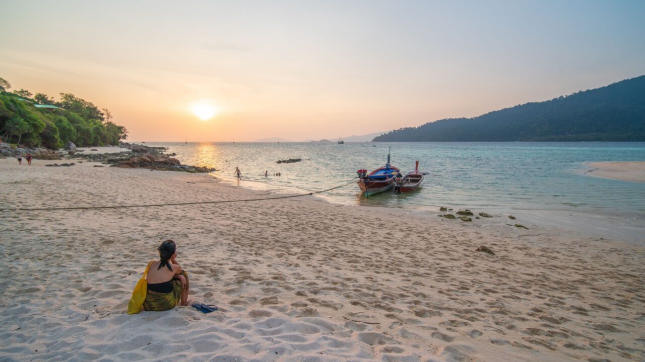 Alone woman traveler at sunset beach view point