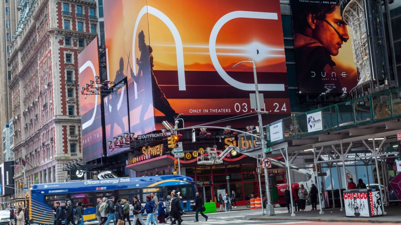 New York NY USA February 11, 2024 Hordes of people cross West 42nd Street under advertising for the Warner Bros. Pictures Dune: Part Two film in Times Square