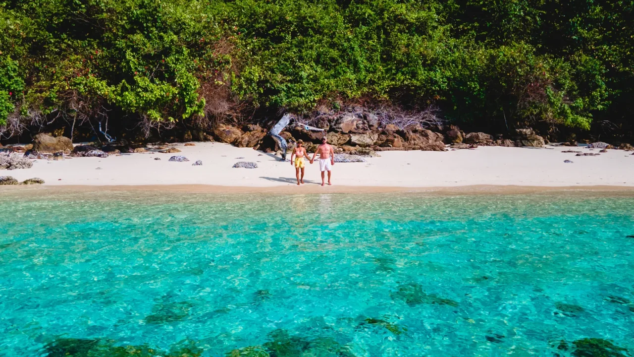 a couple walking on the beach of koh kradan island