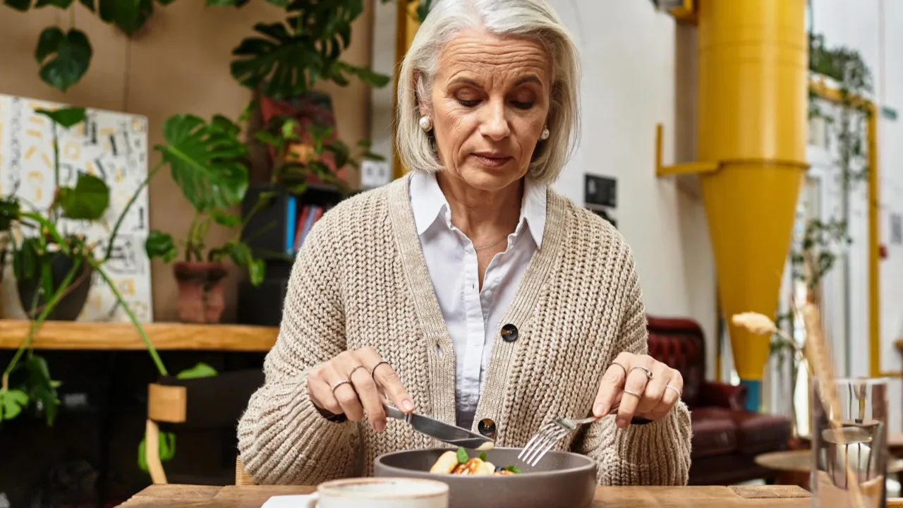 a mature woman with gray hair savors a nutritious dish