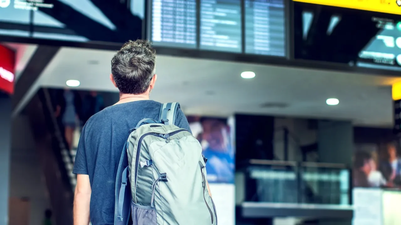 a young male traveler with a backpack in casual style