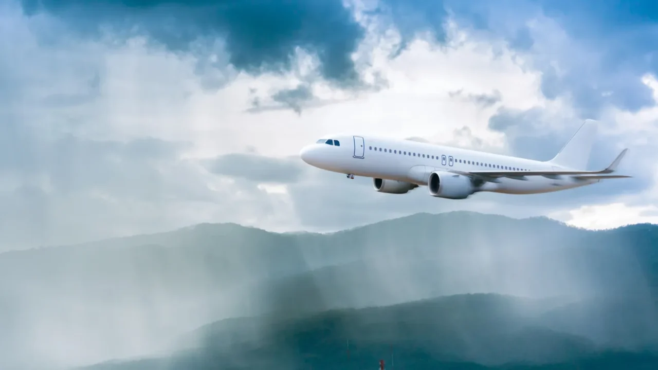 airplane in the sky with rain over mountain the plane