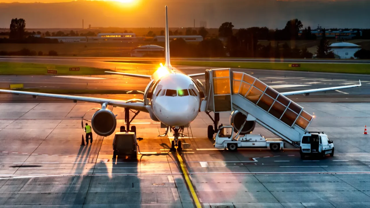 airplane near the terminal in an airport at the sunset