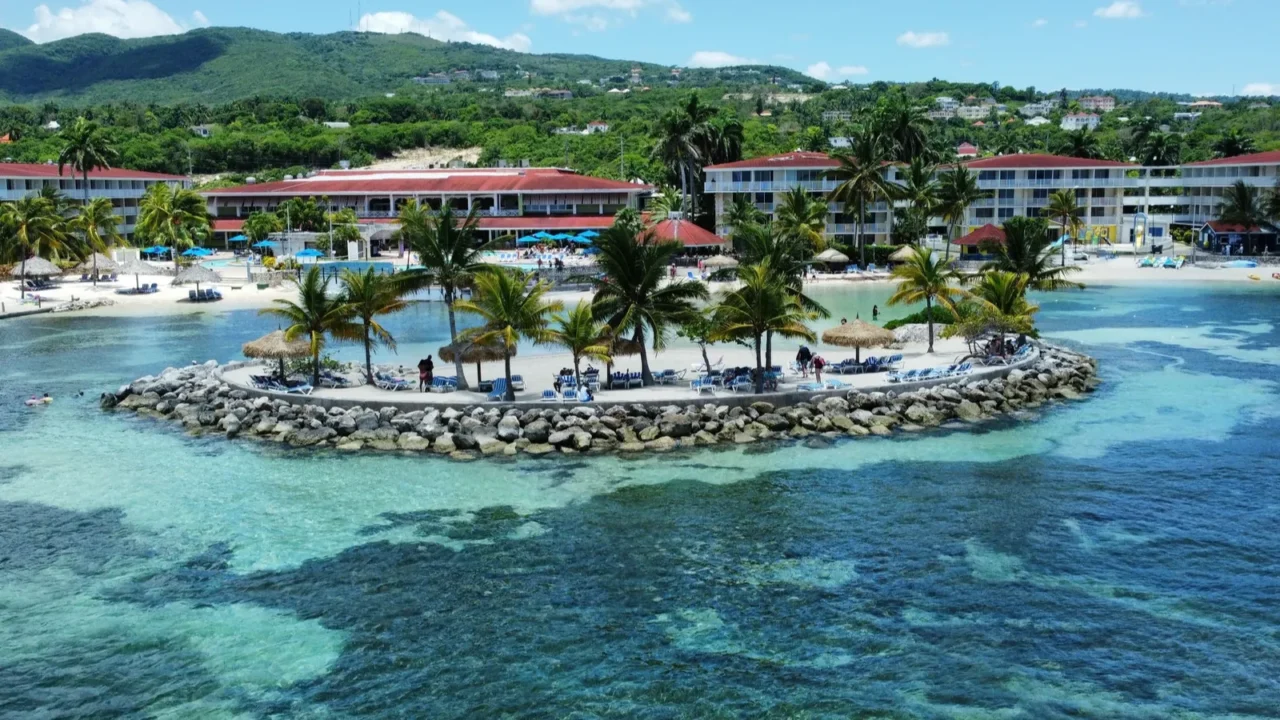 an aerial of hotels on a beach covered with greenery