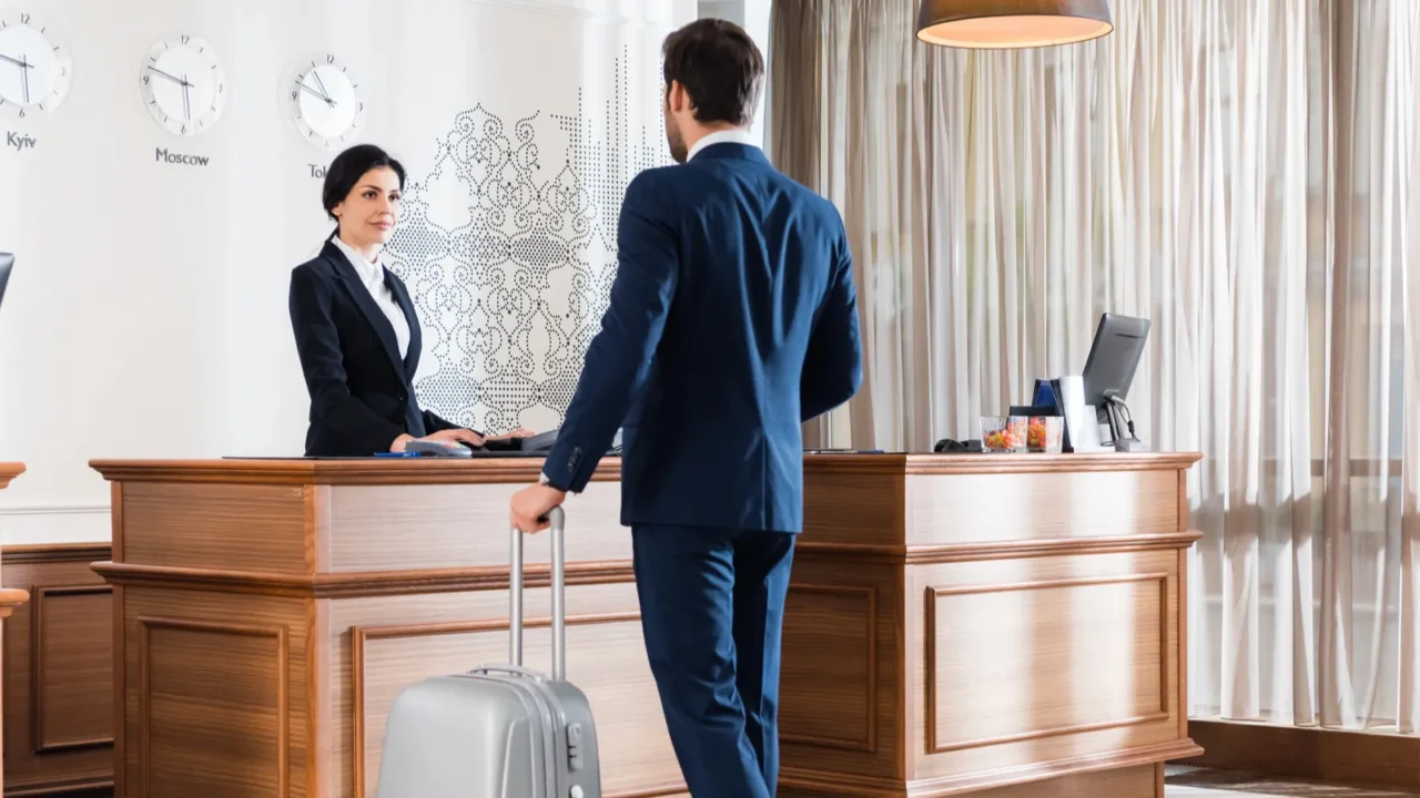 attractive receptionist looking at businessman with luggage