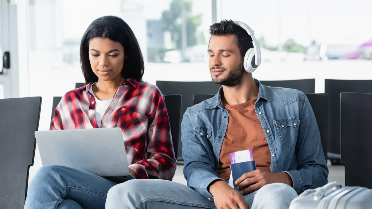 bearded man listening music and looking at laptop near african
