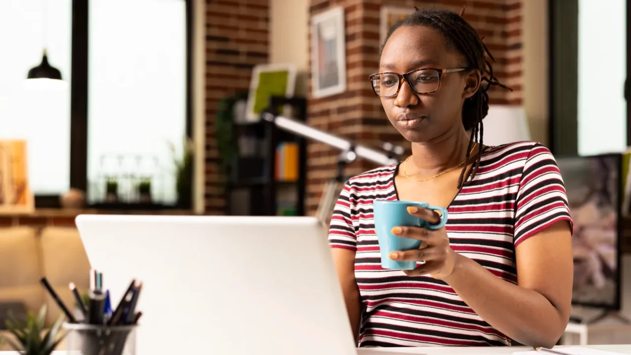 black female entrepreneur holding mug and working on her personal