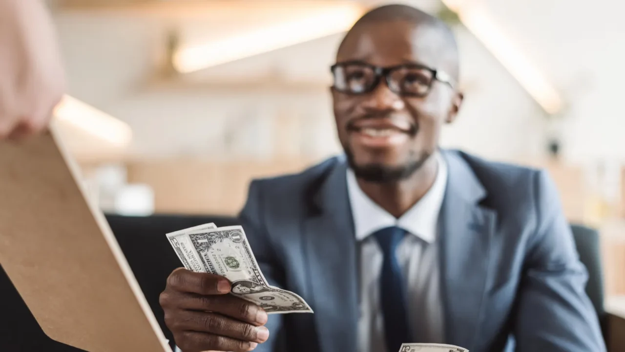 businessman paying with cash in cafe