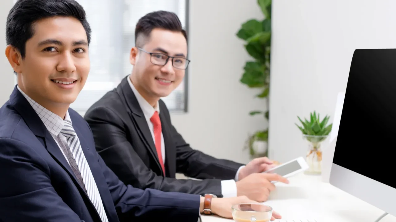 businessmen with colleges smiling in office