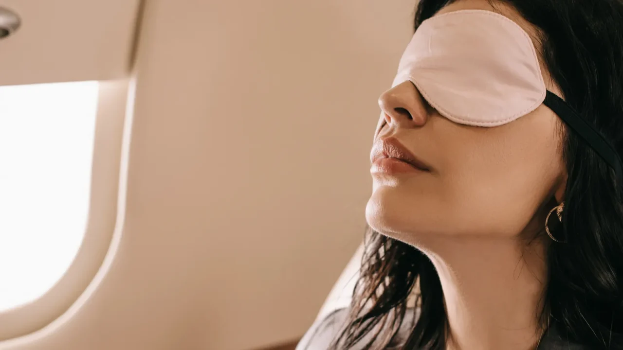 businesswoman in sleeping mask sitting in private jet