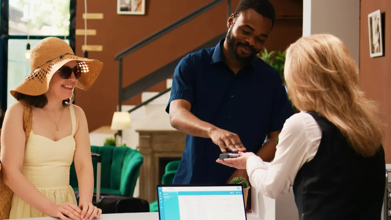 couple paying room accommodation at check in making payment at