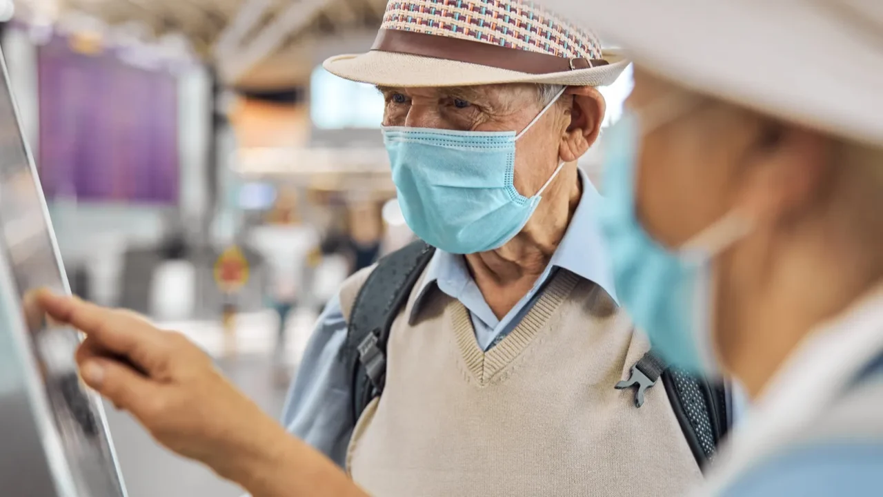 elderly tourist couple checking in their baggage